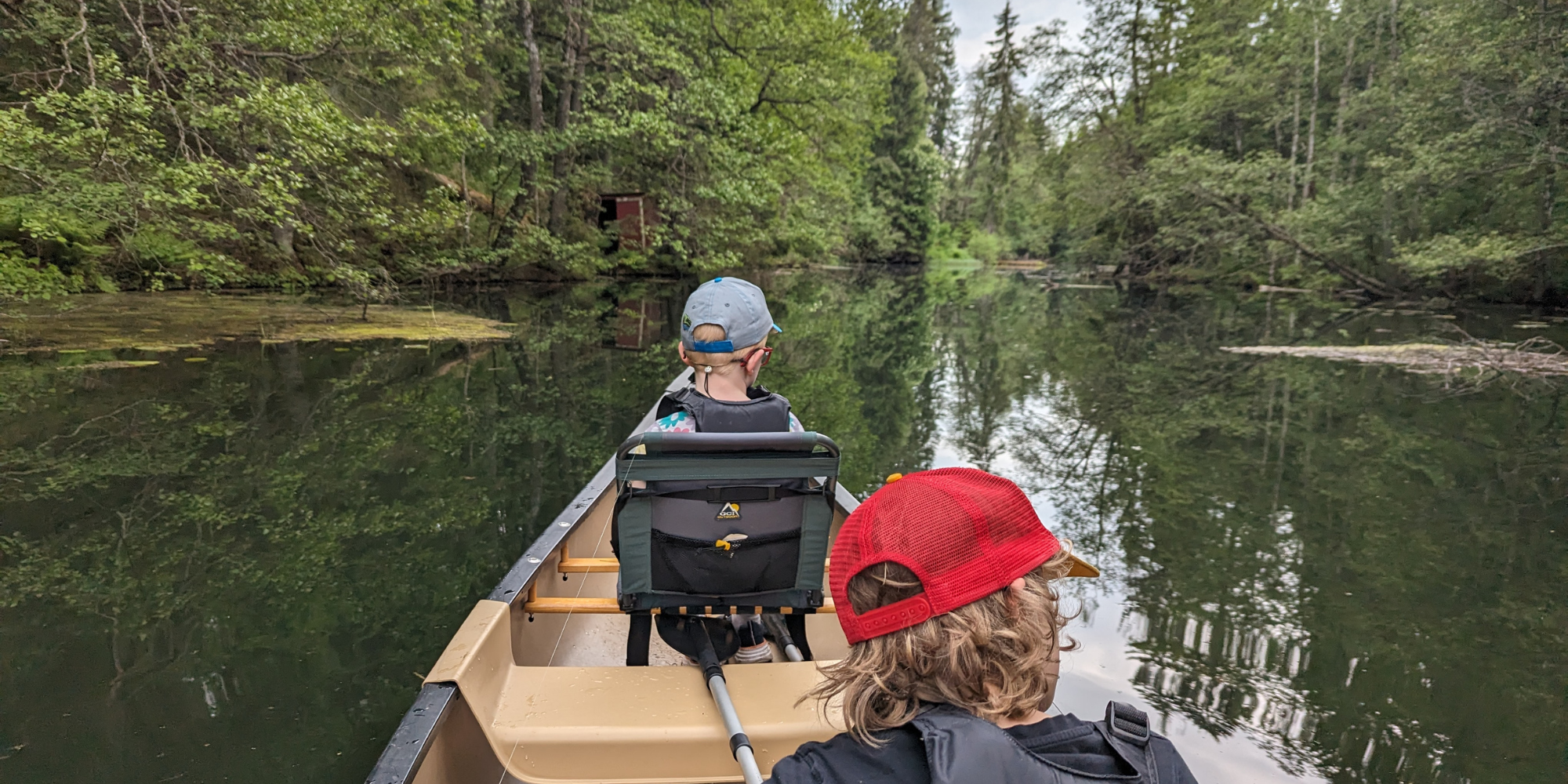 barn som er på kanotur, sett bakfra